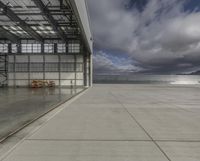 a plane is parked inside a large hangar at the airport in daylight, with a lot of glass on the outside