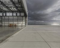 a plane is parked inside a large hangar at the airport in daylight, with a lot of glass on the outside