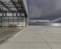 a plane is parked inside a large hangar at the airport in daylight, with a lot of glass on the outside