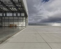 a plane is parked inside a large hangar at the airport in daylight, with a lot of glass on the outside