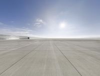 an airplane is taking off from an airport runway with a bright sun in the sky