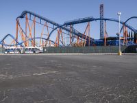 the park has a roller coaster roller coaster and a blue and orange roller coaster at the end of the street