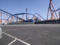 the park has a roller coaster roller coaster and a blue and orange roller coaster at the end of the street