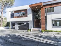 the exterior and landscape of a modern house in los angeles, california with stone and wood