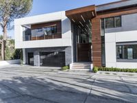 the exterior and landscape of a modern house in los angeles, california with stone and wood