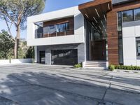 the exterior and landscape of a modern house in los angeles, california with stone and wood