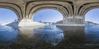 the view from a perspective looking at two large arches with water on either side and in the center