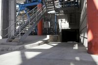 the industrial steel staircases lead up to a tunnel at the side of a large building