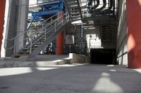 the industrial steel staircases lead up to a tunnel at the side of a large building