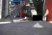 the industrial steel staircases lead up to a tunnel at the side of a large building