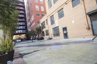 a small courtyard in the middle of a big city area with some trees and flowers