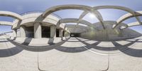 the view of a circle like structure in front of some columns with the sun shining over them