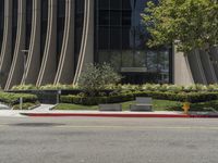 the yellow fire hydrant is near the large modern building on the side of the road