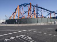 roller coasters on a track in an empty parking lot with a stop sign and a sign saying ride