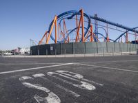 roller coasters on a track in an empty parking lot with a stop sign and a sign saying ride