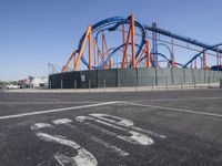 roller coasters on a track in an empty parking lot with a stop sign and a sign saying ride