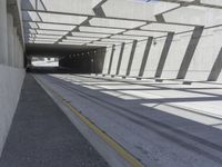 a large long narrow tunnel with one side facing towards the camera, which is paralleled by two concrete pillars