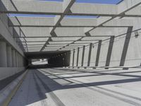 a large long narrow tunnel with one side facing towards the camera, which is paralleled by two concrete pillars