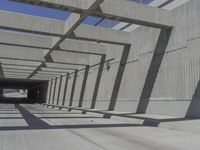 a large long narrow tunnel with one side facing towards the camera, which is paralleled by two concrete pillars