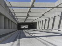 a large long narrow tunnel with one side facing towards the camera, which is paralleled by two concrete pillars