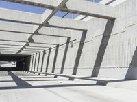 a large long narrow tunnel with one side facing towards the camera, which is paralleled by two concrete pillars