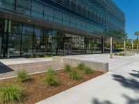 two grey blocks sitting next to a tall building on a sidewalk in front of grass