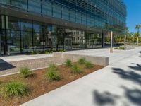 two grey blocks sitting next to a tall building on a sidewalk in front of grass