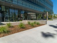 two grey blocks sitting next to a tall building on a sidewalk in front of grass