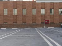 a parking lot is lined with white lines on the ground and an old red brick building is in the distance