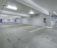 empty parking lot with two large white signs on the wall and several lights above it