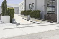a couple of concrete planters sit in front of an office building on a street
