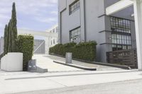 a couple of concrete planters sit in front of an office building on a street