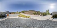 a wide angle view of several skateboards and trees in a parking lot below a mountain