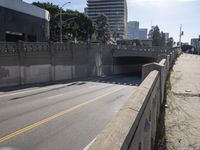 a street with a bridge over the road and cars driving under the overpassed roadway