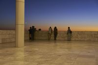 the wall has columns near a railing overlooking the water, and a light beam has been cast