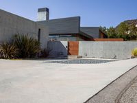 a gray concrete building with stairs and door at the top of the floor next to it is steps leading down to the doorway