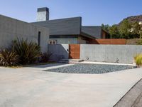 a gray concrete building with stairs and door at the top of the floor next to it is steps leading down to the doorway