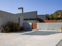 a gray concrete building with stairs and door at the top of the floor next to it is steps leading down to the doorway