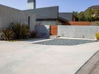 a gray concrete building with stairs and door at the top of the floor next to it is steps leading down to the doorway