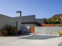 a gray concrete building with stairs and door at the top of the floor next to it is steps leading down to the doorway