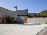 a gray concrete building with stairs and door at the top of the floor next to it is steps leading down to the doorway