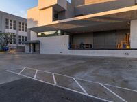 a empty parking space in front of large concrete building on sunny day with blue skies