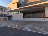 a empty parking space in front of large concrete building on sunny day with blue skies