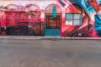 a fire hydrant on the side of a road with red graffiti painted all over it