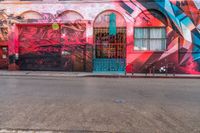 a fire hydrant on the side of a road with red graffiti painted all over it