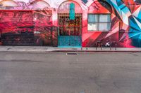 a fire hydrant on the side of a road with red graffiti painted all over it