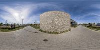 this is a fish eye lens shot of a building with the roof open, it appears to be made of bricks