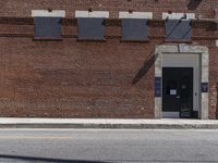 a building with a sign next to the door in front of it is brick and white painted