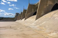 concrete walls with a sky background on the ground of an empty lot, with dirt and cement around