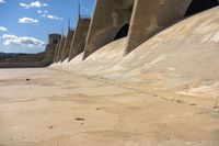 concrete walls with a sky background on the ground of an empty lot, with dirt and cement around